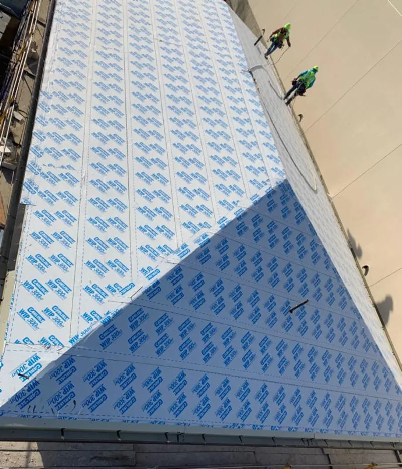 Professional roofers installing underlayment on a metal roof in Lennox